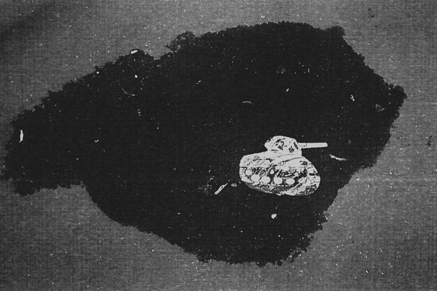 Deflated balloon in the form of a Soviet tank in a puddle on a city street. Moscow, Russia.