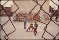 35. Three Boys and "A Train" Graffiti in Brooklyn's Lynch Park in New York City. The Inner City Today Is an Absolute Contradiction to the Main Stream America of Gas Stations, Expressways, Shopping Centers and Tract Homes. It Is Populated by Blacks, Latins and the White Poor. Most of All, the Inner City Environment Is Human Beings as Beautiful and Threatened as the 19th Century Buildings 06/1974. Photographer: Danny Lyon