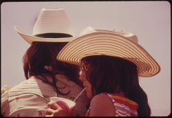 27. Young Woman Sips a Soft Drink While Riding behind Her Friend on a Horse at Cottonwood Falls, Kansas, near Emporia, 06/1974. Photographer: Patricia D. Duncan