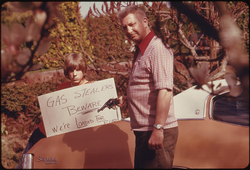 31. Country's Fuel Shortage Led to Problems for Motorists in Finding Gas as Well as Paying Much More for It, and Resulted in Theft From Cars Left Unprotected. This Father and Son, Made a Sign Warning Thieves of the Possible Consequences 04/1974. Photographer: David Falconer